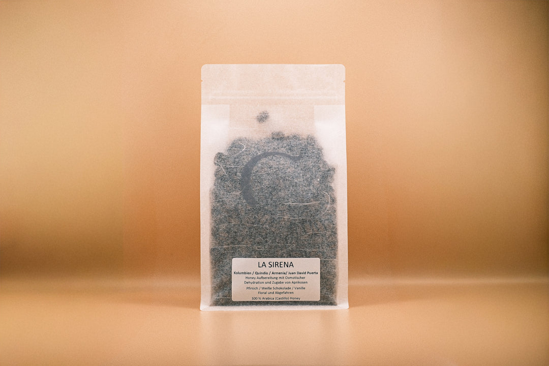 Verpackung von LA SIRENA mit gemahlenem Kaffee und Zutaten auf goldenem Hintergrund.