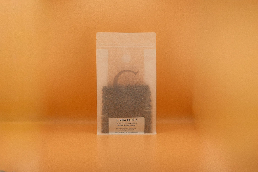 SHYIRA HONEY - rooibusch & mandarine Verpackung auf orangefarbenem Hintergrund