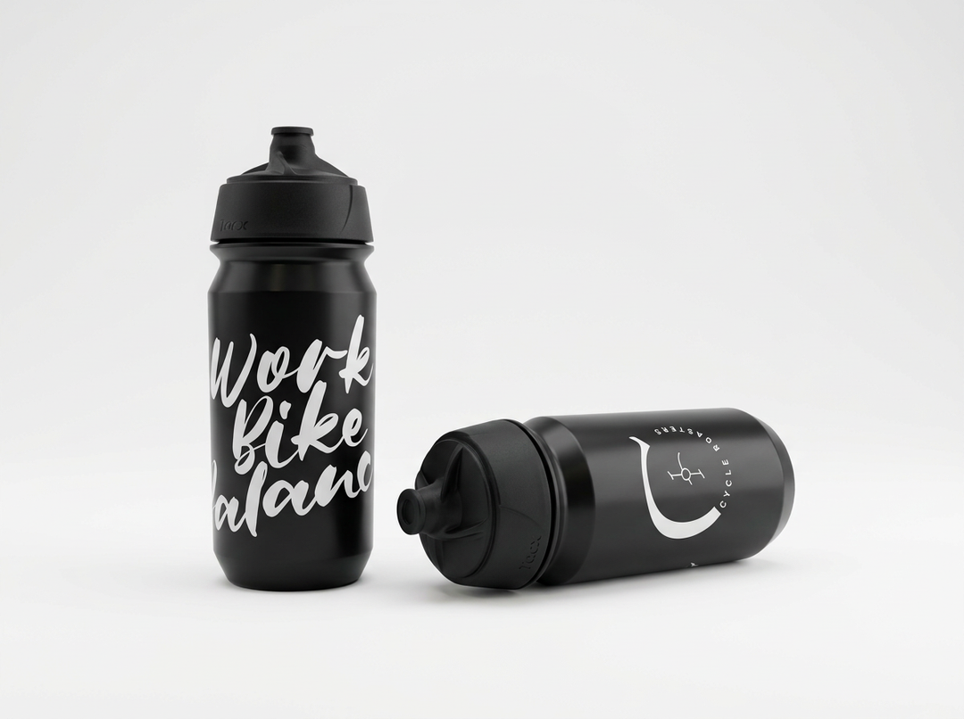 Schwarze Tacx Trinkflasche „Work Bike Balance“ von Cycle Roasters, stehend und liegend mit rundem Logo